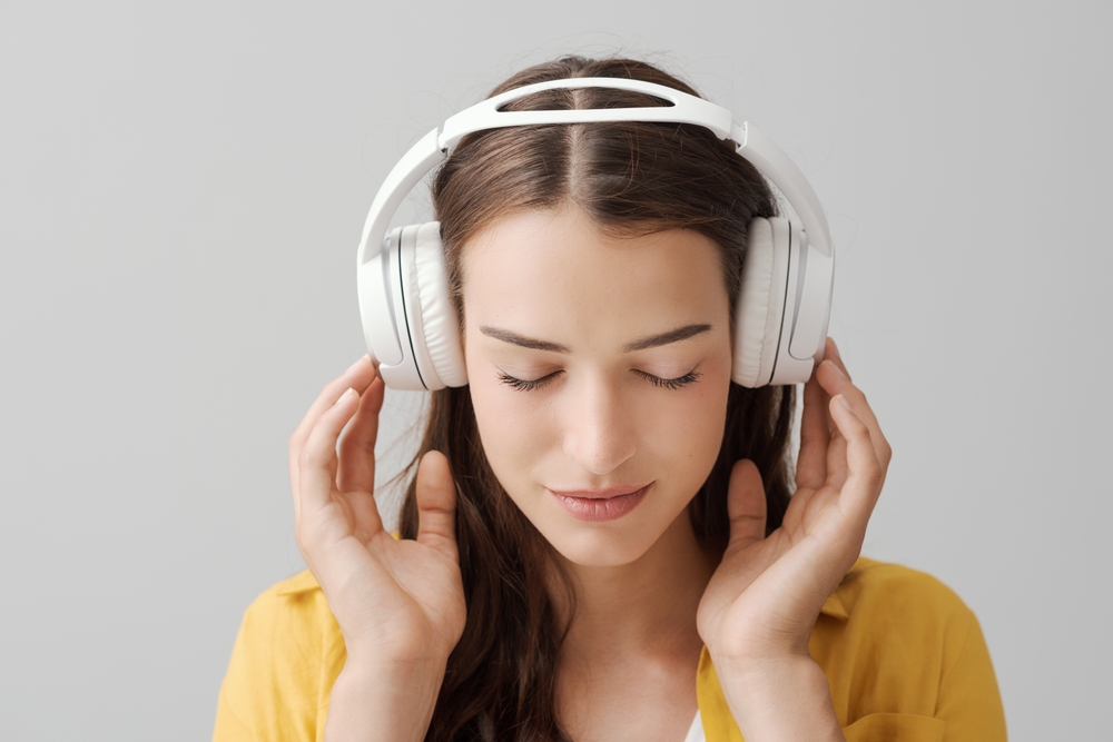 Avslappnad kvinna som lyssnar i hörlurar